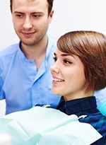 Woman in dental chair looking at smile in mirror