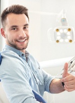 man giving a thumbs up in the dental chair 