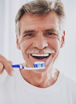 man brushing his teeth  