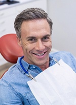 A smiling man sitting in a dentist’s chair