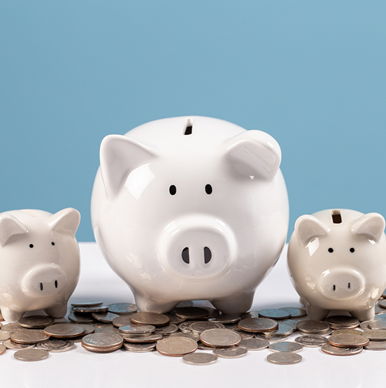 Three piggy banks next to a pile of coins