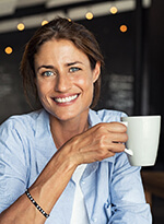 smiling woman holding a white coffee mug 