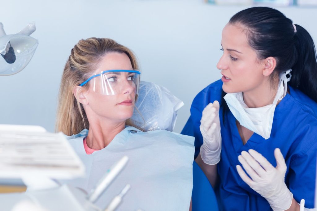 patient speaking with dentist about how dental implants in Norwood feel