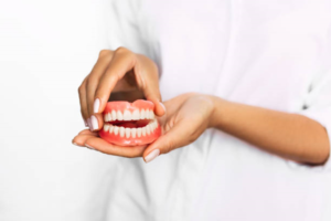 a closeup of someone holding dentures
