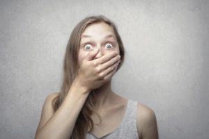 Panicked woman covering her mouth