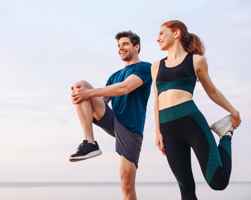 Couple doing leg stretches in exercise gear