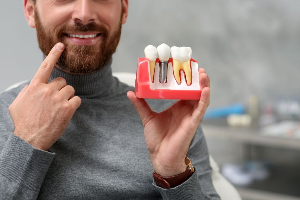 A man holding a dental implant model